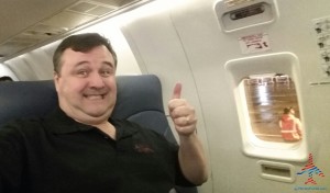 a man sitting in an airplane with his thumb up