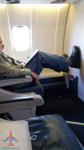 man with both feet up on bulkhead wall delta first class renespoints blog