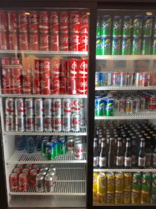 a refrigerator full of cans of soda and other beverages