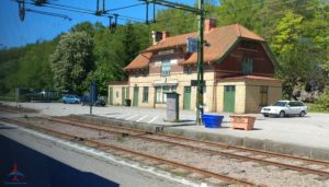 a train station with a building and train tracks