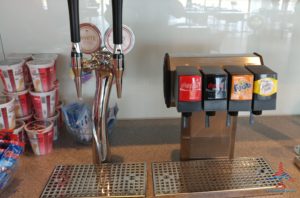 a group of soda dispensers next to a dispenser