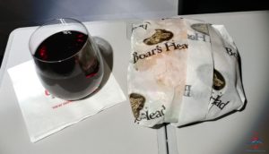 a glass of wine next to a sandwich