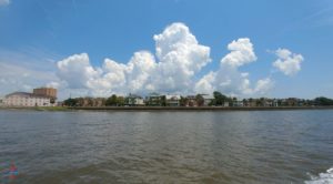a body of water with buildings and clouds in the sky