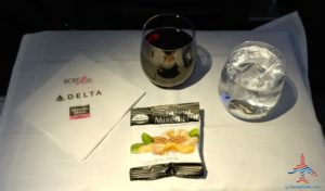 a glass of wine next to a packet of sugar