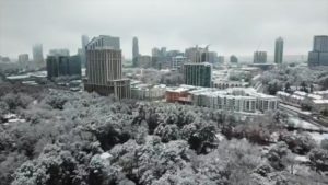 a city with snow covered trees