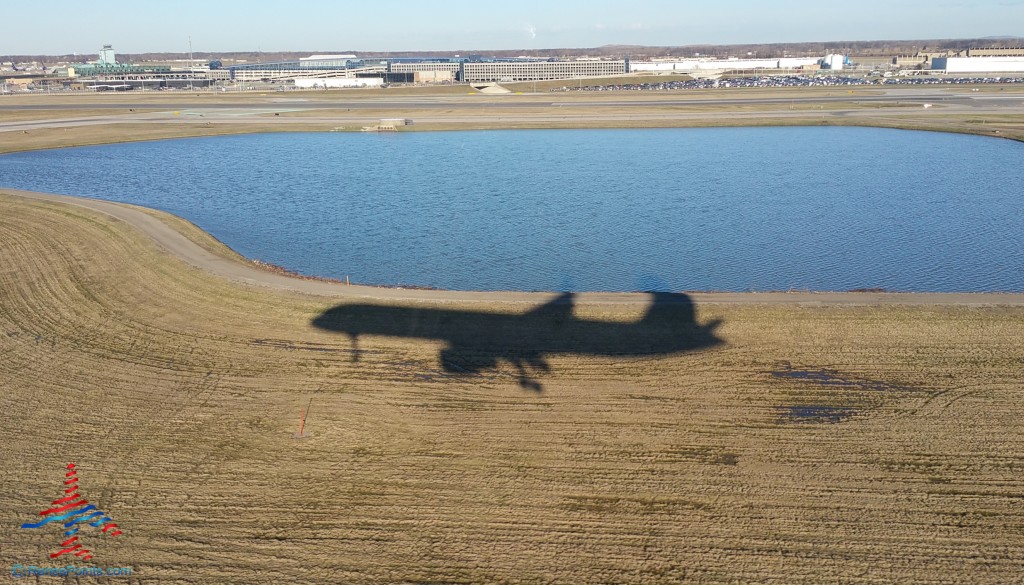 a shadow of an airplane on a field with water