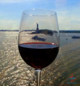 a glass of wine with a statue of liberty in the background