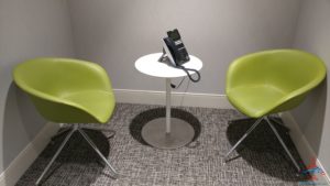 a telephone on a table with green chairs