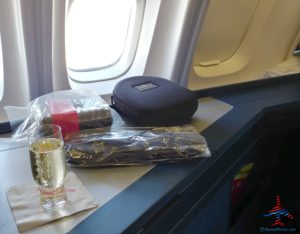 a glass of champagne next to a bag of food