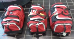 a group of red and black duffel bags