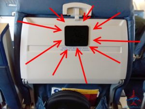 an airplane seat with red arrows pointing to the back of it