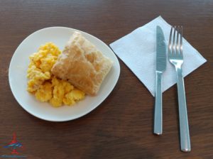 a plate of scrambled eggs and pastry