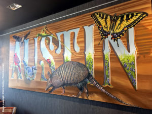 Artwork reading "Austin" with an armadillo is seen at the Delta Sky Club Austin airport lounge at Austin-Bergstrom International Airport (AUS) in Austin, Texas. Photo © Chris Carley / PointsLounge