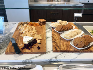 A cheese board with cranberries, walnuts, and dried apricots is displayed next to a selection of desserts at the Delta Sky Club Austin airport lounge in Austin, Texas. Photo © Chris Carley / PointsLounge