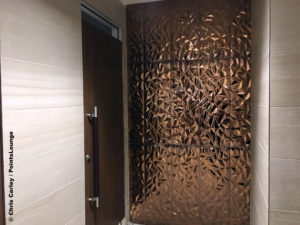 Copper artwork is seen inside the men's restroom at the Delta Sky Club Austin airport lounge at Austin-Bergstrom International Airport (AUS) in Austin, Texas. Photo © Chris Carley / PointsLounge