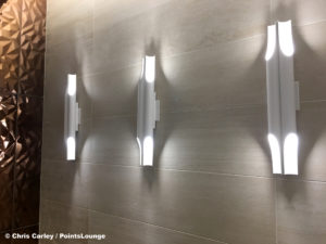 Light sconces are seen inside the men's restroom at the Delta Sky Club Austin airport lounge at Austin-Bergstrom International Airport (AUS) in Austin, Texas. Photo © Chris Carley / PointsLounge