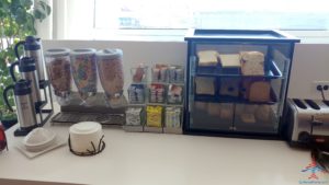 a counter with a glass case and a group of coffee cups