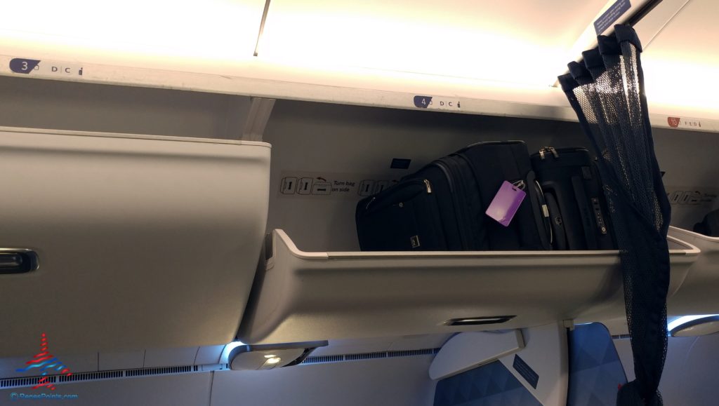 luggage in a shelf on an airplane