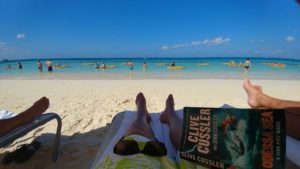 a person lying on a beach with a book