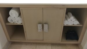 a cabinet with shelves and towels