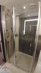 a shower with a sink and a shower head