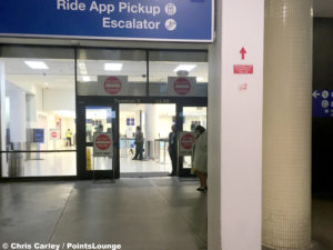 A G2 Secure Staff employee guards a door outside LAX Terminal 3 security.