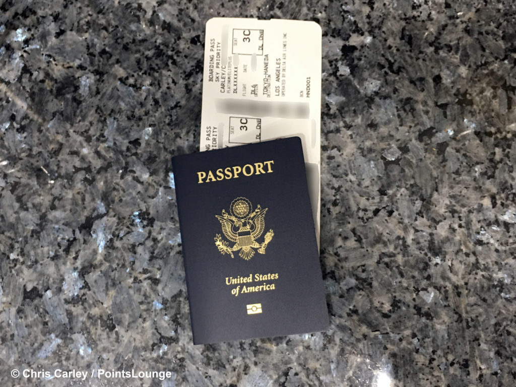 A Delta One boarding pass for a flight from Tokyo Haneda to Los Angeles International Airport - LAX - is tucked inside a US passport.