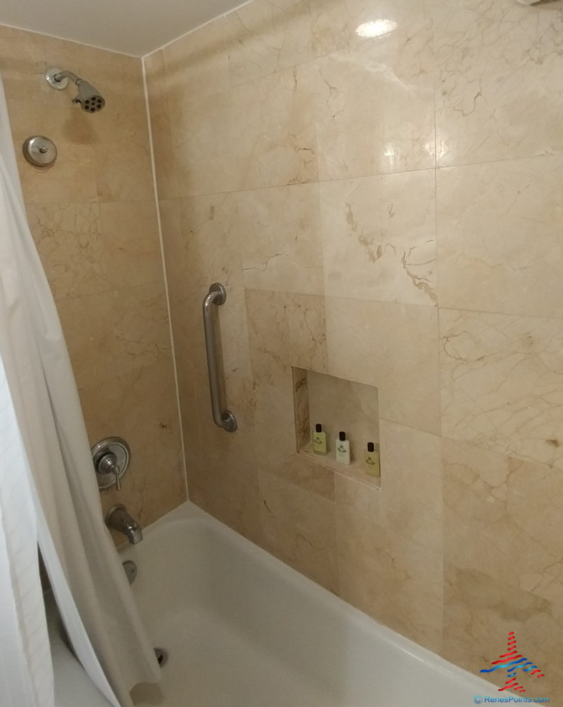 a shower with a shower head and a shower curtain