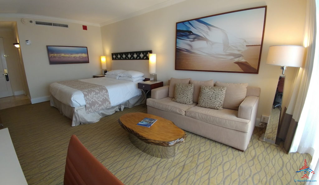a hotel room with a bed and couches