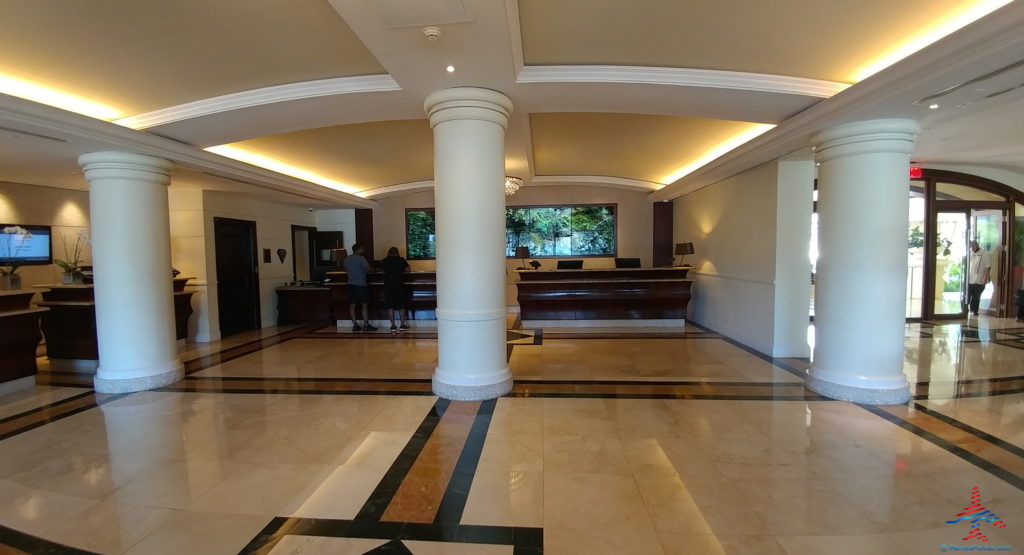 a lobby with a large white column and a couple people standing in front of it