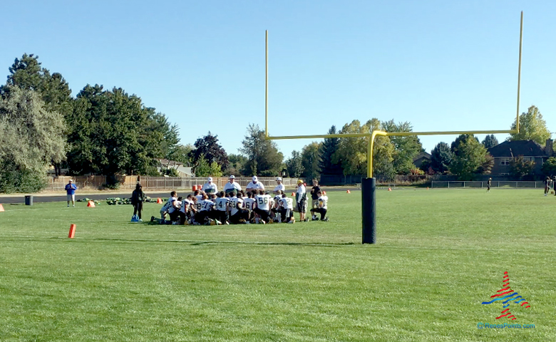 A high school football team huddles prior to a game in Boise, Idaho.