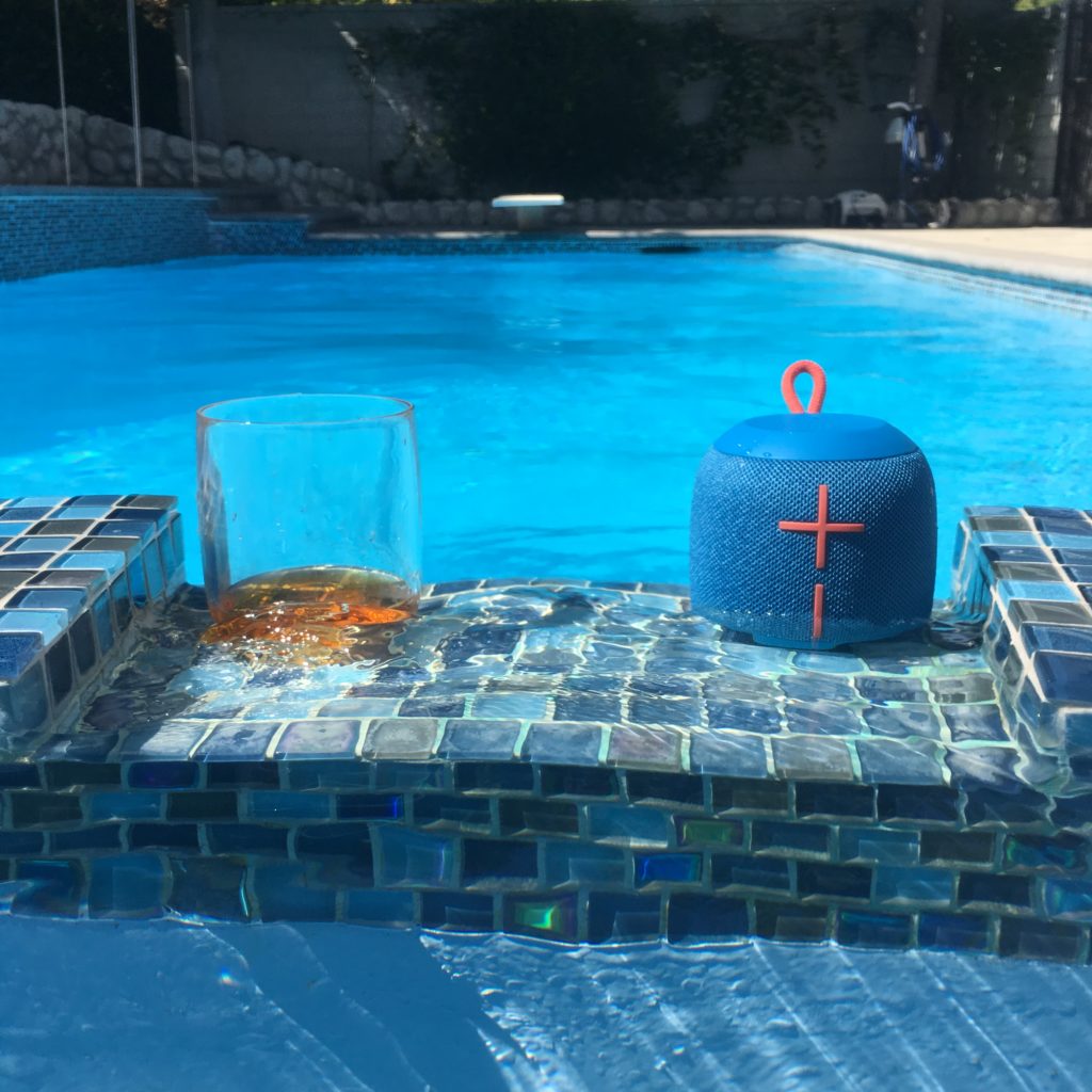 a bluetooth speaker on a pool edge