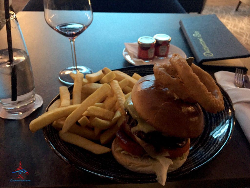A barbecue cheeseburger with fries (chips) and onion rings is seen inside the bar at the Holiday Inn Express London Heathrow T4 and Crowne Plaza (LHR airport hotels) in Hounslow, United Kingdom.