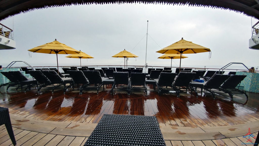 a deck with chairs and umbrellas on a cloudy day