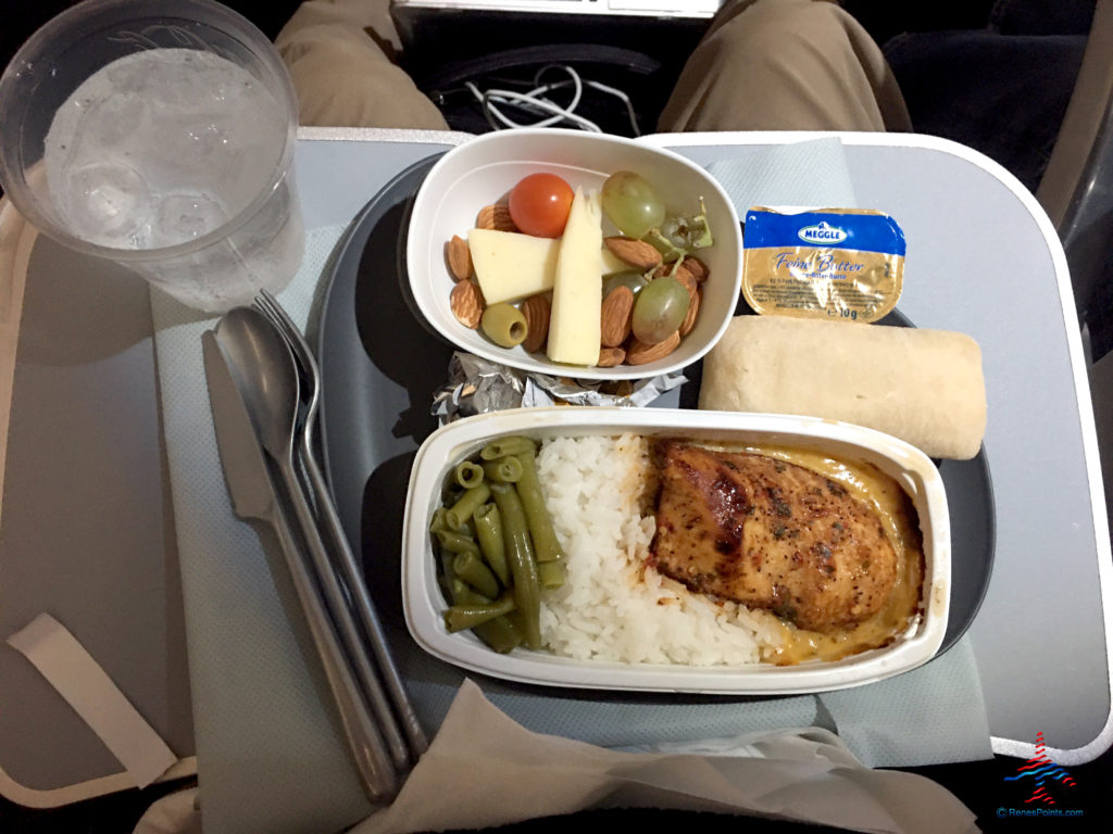 Marinated chicken breast, green beans, rice, bread, and fruit and cheese with almonds are featured as part of Delta's Main Cabin international experience as seen on a Delta Air Lines Airbus A330-300 flight from London Heathrow to Atlanta Hartsfield Airport.