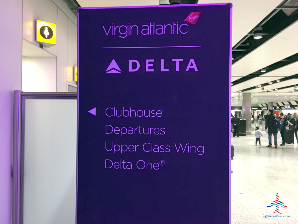 Signage in Terminal 3 check-in area directs guests to the invited guests elevator/lift and Virgin Atlantic Clubhouse airport lounge at London Heathrow Airport (LHR).