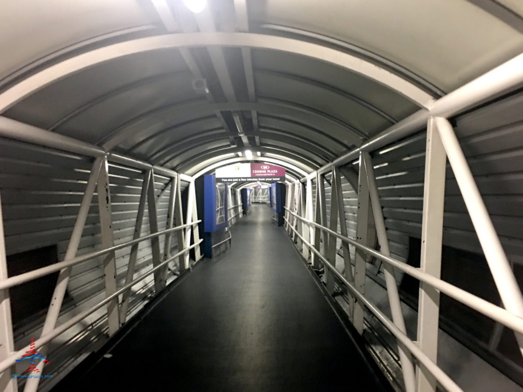 Signage in a tunnel directs guests to the Crowne Plaza and Holiday Inn Express, Hilton, and Premier Inn LHR airport hotels in Hounslow, United Kingdom.