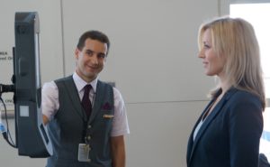 A Delta employee guides a passenger through the facial recognition process.