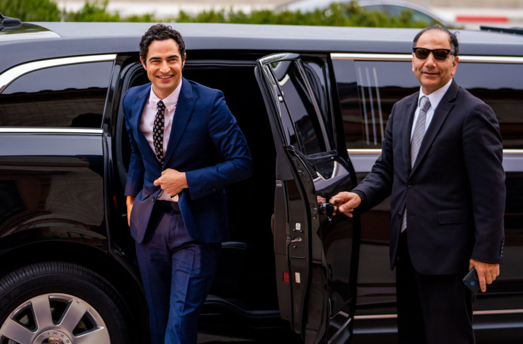 a man in a suit and tie getting out of a car