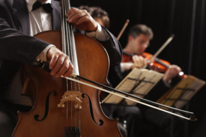 Symphony concert, a man playing the cello, hand close up