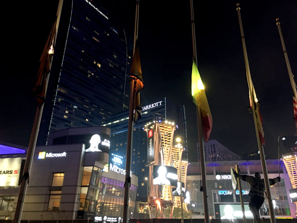 Images of the late Kobe Bryant are projected onto screens at LA Live outside STAPLES Center, where flags are lowered at half-mast.