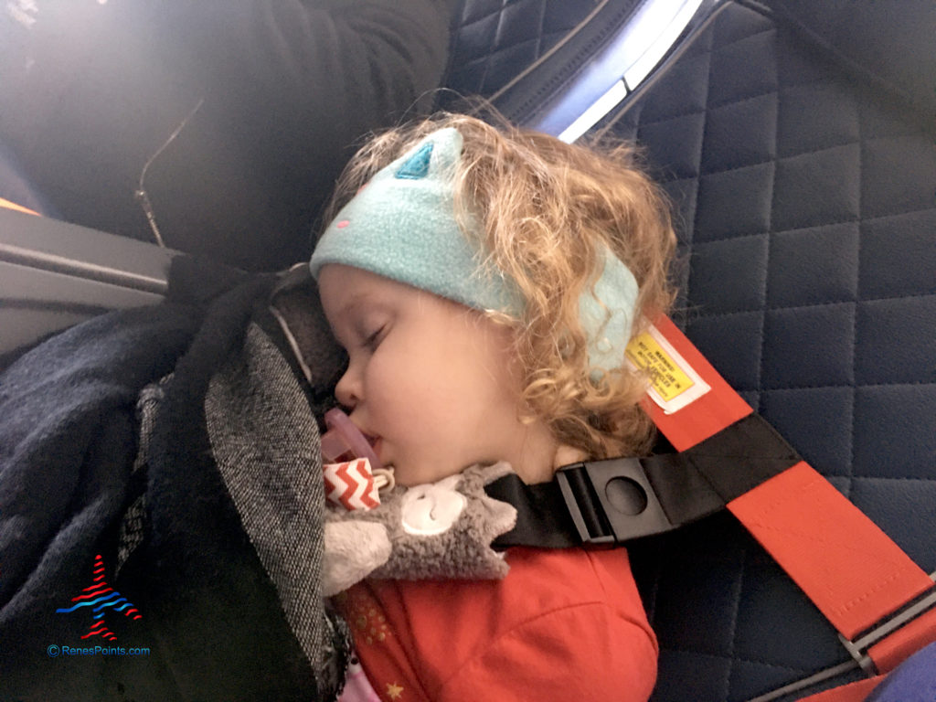 A toddler sleeps on an airplane