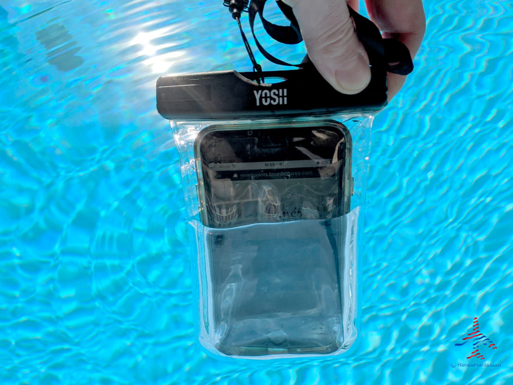 An iPhone 6S Plus is dipped into a swimming pool and protected with a YOSH waterproof cell phone pouch.