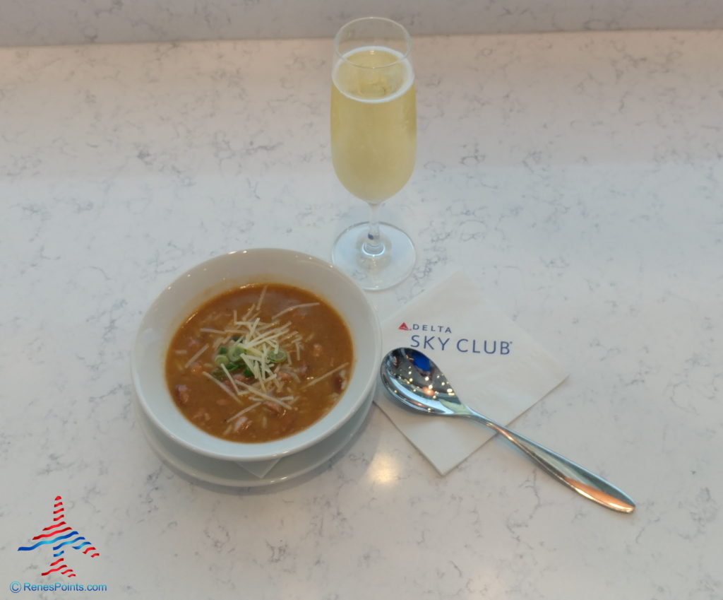 a bowl of soup next to a glass of champagne