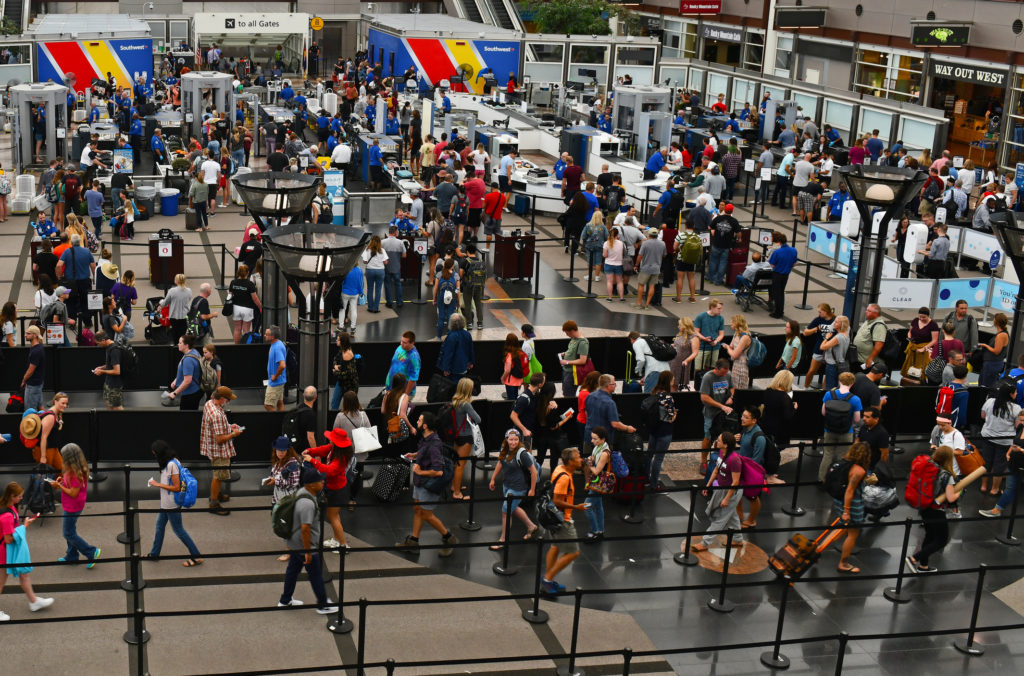 Crowds of travelers in long queue at TSA Security Check at Denver International Airport over summer holiday weekend.