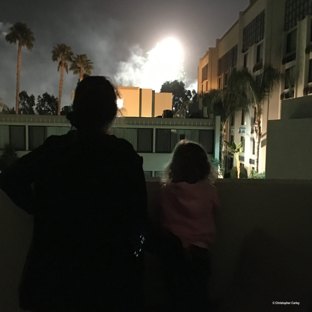 Two guests watch fireworks from a balcony at the Holiday Inn & Suites Anaheim hotel near Disneyland in Anaheim, California.