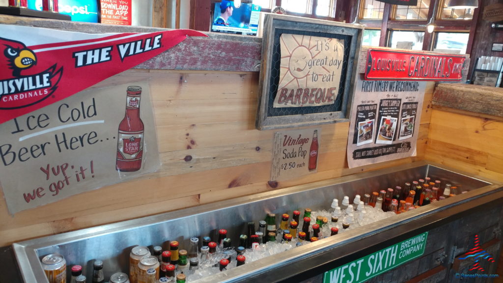 a bar with a cooler and bottles of soda