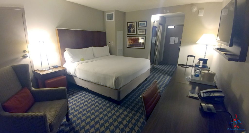 a hotel room with a bed and desk