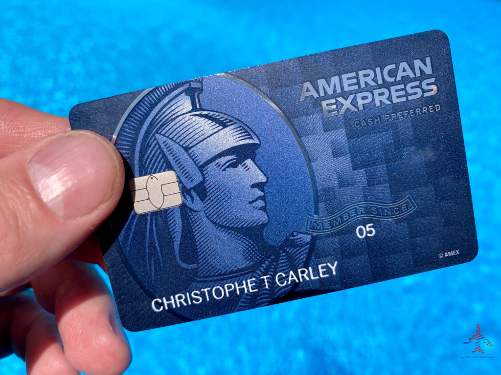 The American Express Blue Cash Preferred Card is seen against a swimming pool during a vacation travel trip.