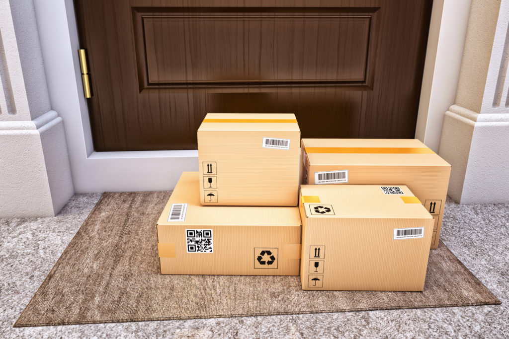 Shipping boxes are seen on a doorstep.